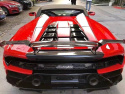 Widok Lamborghini spyder z tyłu widok z boku. Samochód cały pokryty folią ochronną w połysku w kolorze czerwony metailk.