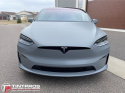 Tesla przed grażem widok frontu. Samochód w kolorze satin grey. Folia ochronna do zmiany koloru gswf.